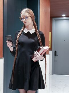 Pitkä mustatukkainen lukutoukka, jolla on silmälasit, pannaan lävistettyihin sukkahousuihin